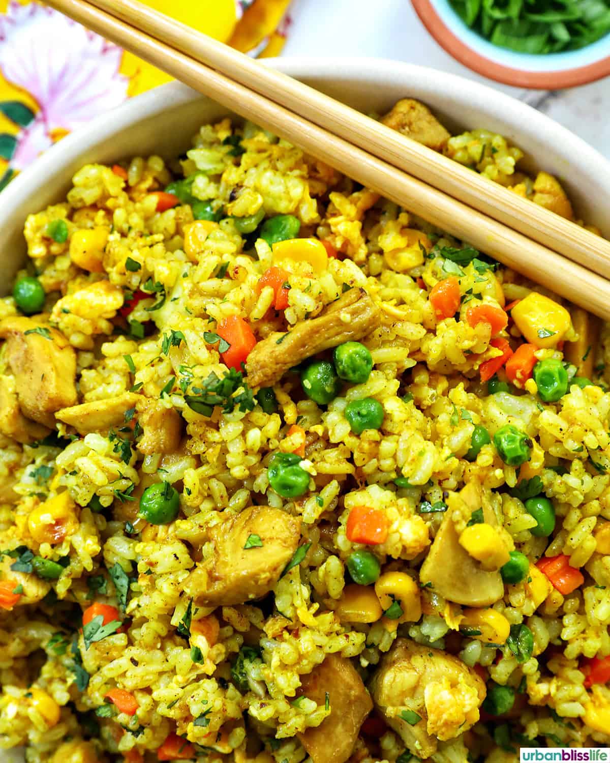 bowl of curry chicken fried rice and chopsticks.
