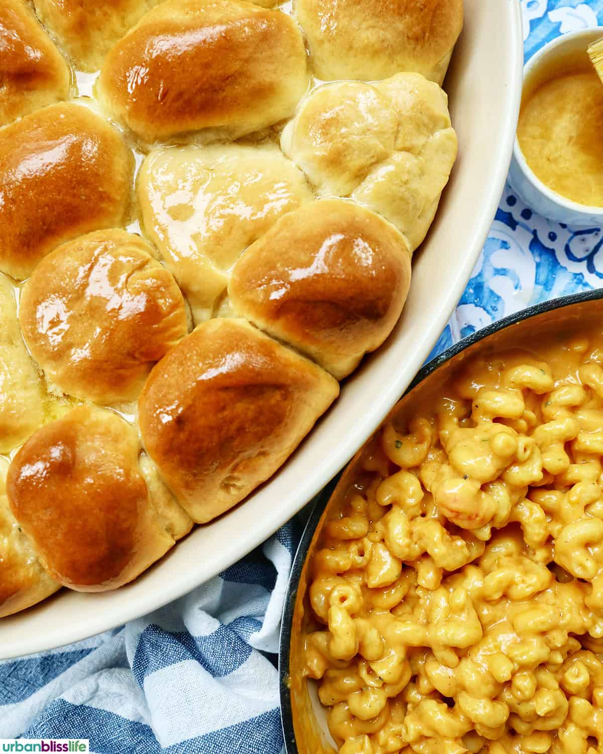 honey butter rolls in a serving platter next to a pan of lobster mac and cheese.