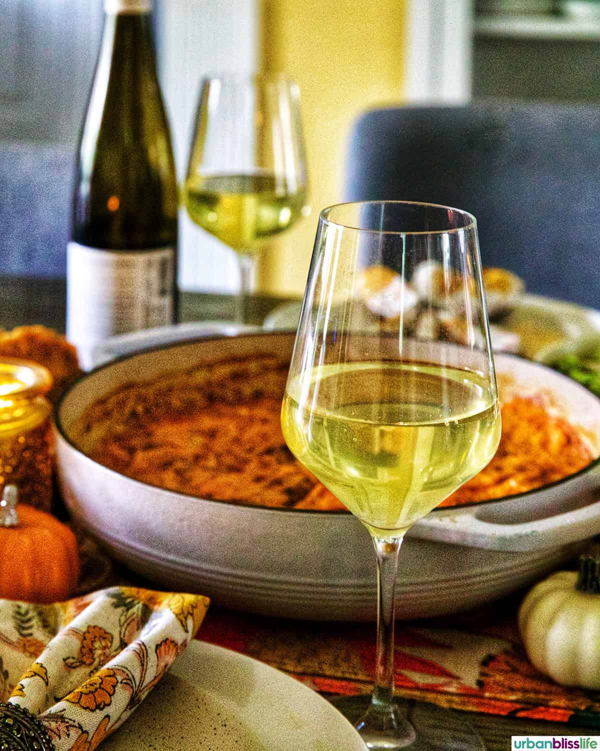 glass of white wine on a fall-themed table.