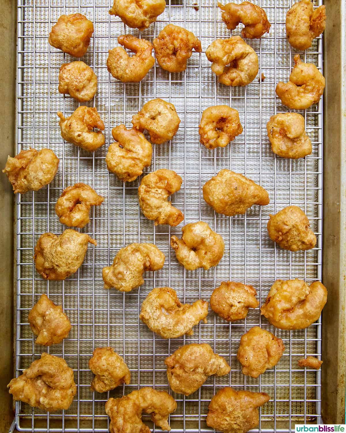 beer battered shrimp on a wire rack.