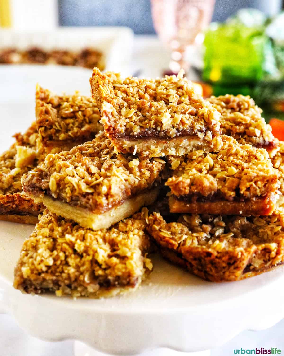 stack of apple pie bars on a white pedestal.