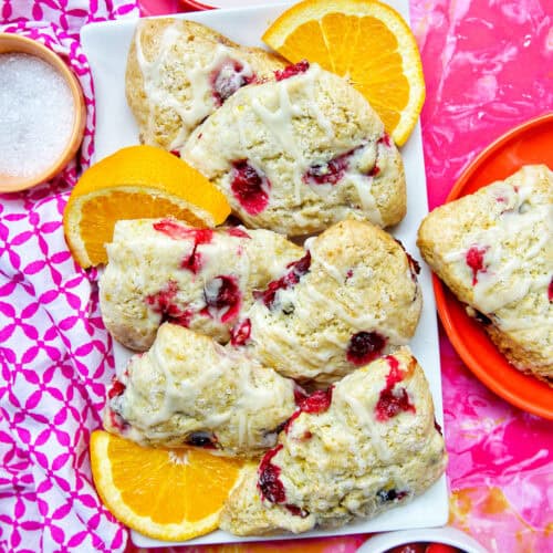 These orange cranberry scones are perfect for breakfast, brunch, or afternoon tea. Bright, buttery, and bursting with cranberries & citrus. Get the easy pastry recipe at UrbanBlissLife.com.