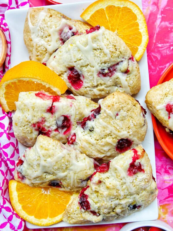 These orange cranberry scones are perfect for breakfast, brunch, or afternoon tea. Bright, buttery, and bursting with cranberries & citrus. Get the easy pastry recipe at UrbanBlissLife.com.