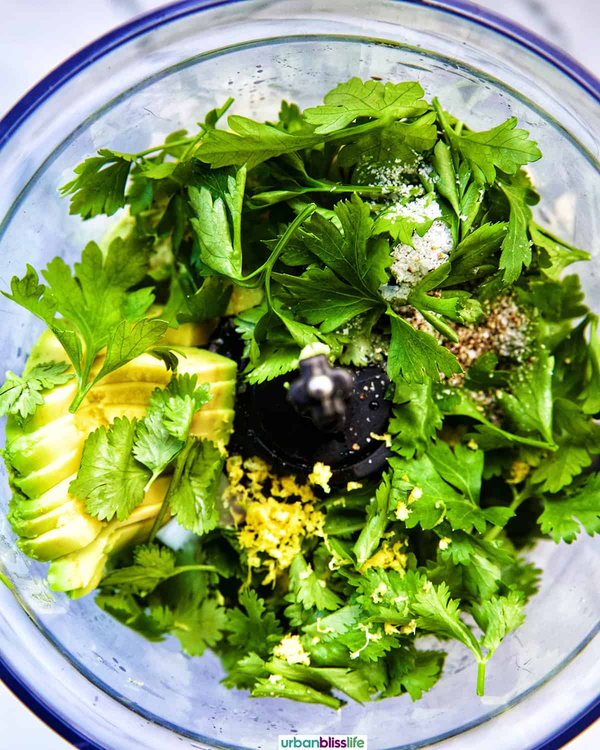 herbs, garlic, and other ingredients to make vegan green goddess dressing in a food processor.