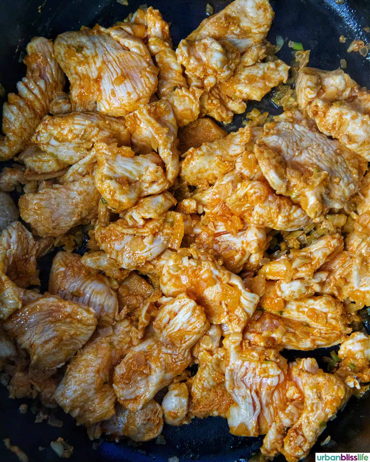chicken seasoned and cooking in a Dutch oven.