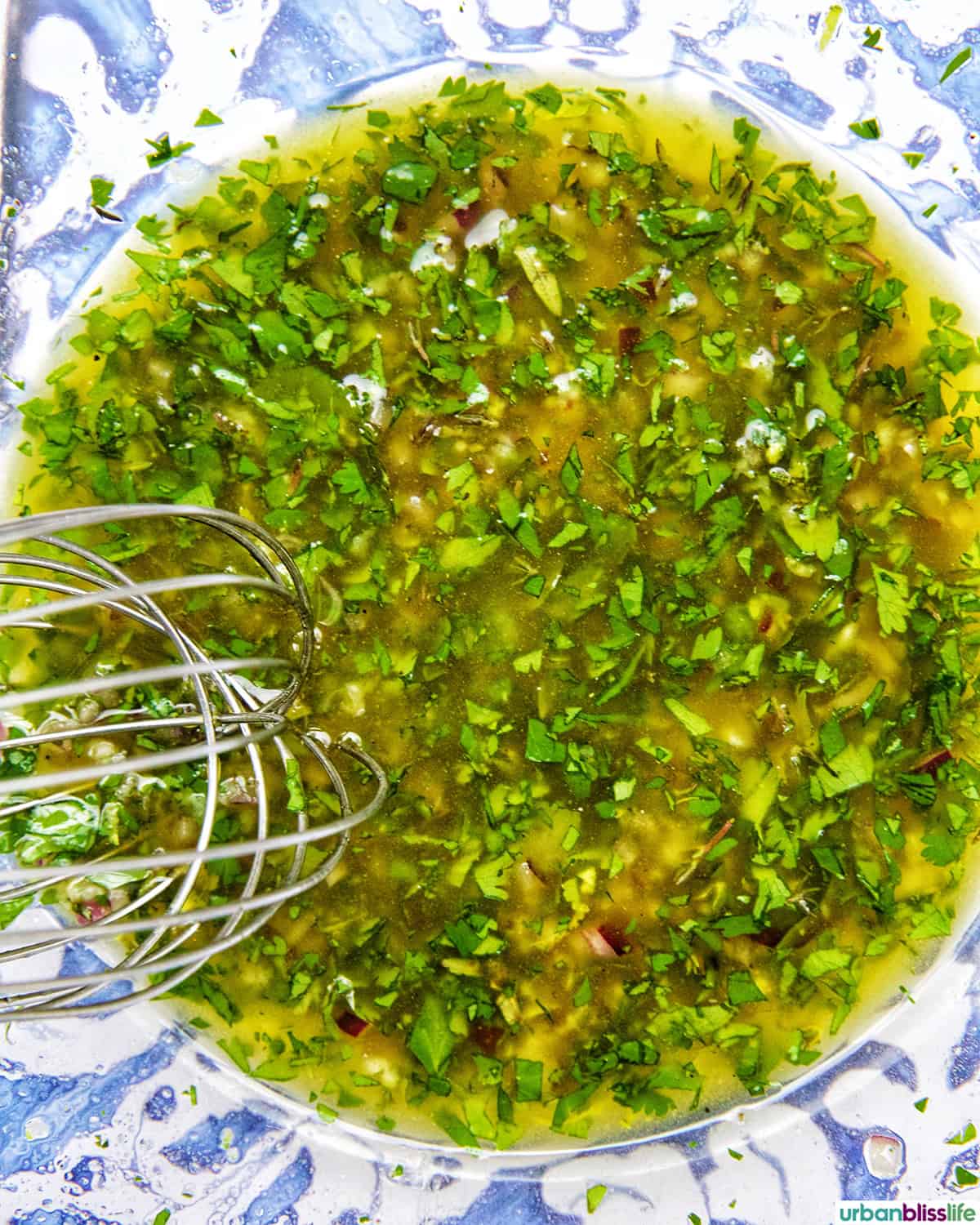 bowl of lemon vinaigrette with whisk.