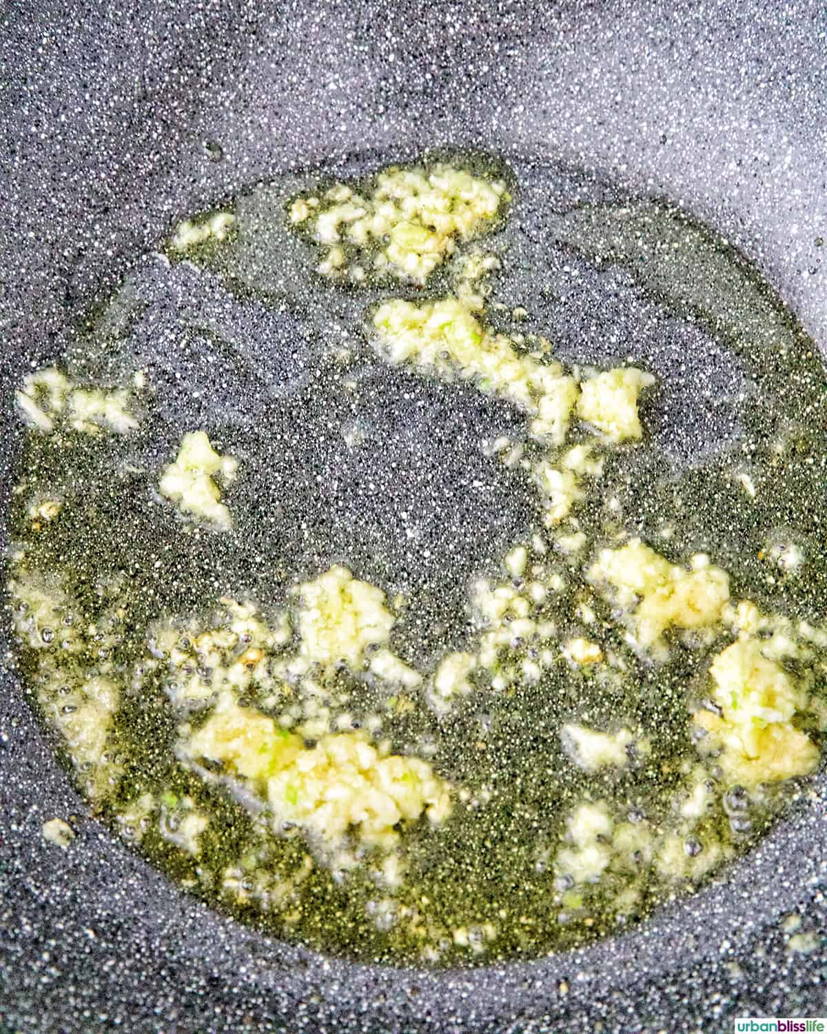 garlic and ginger sauteing in a wok.