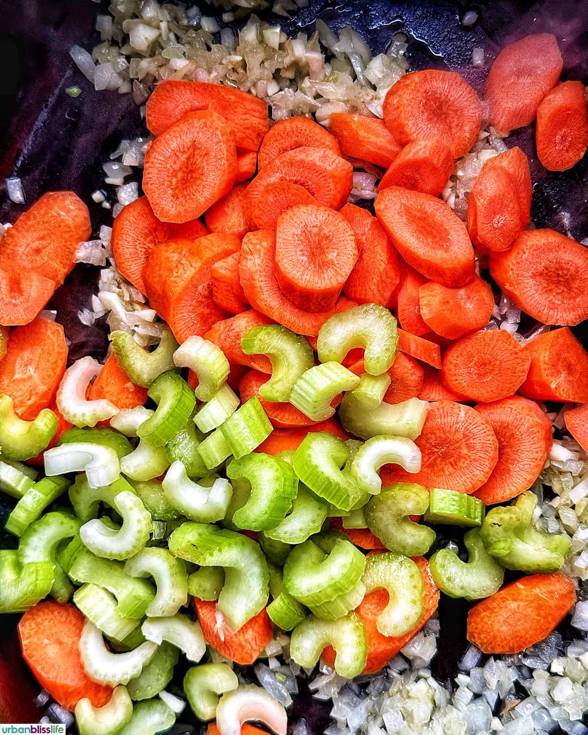 carrots, celery, onions, and garlic cooking in a dutch oven.