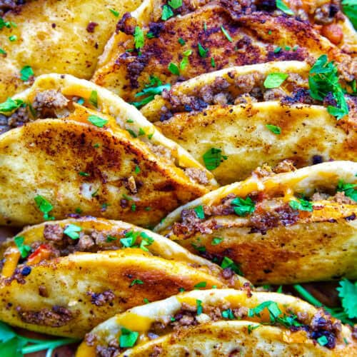plate full of crispy beef tacos.