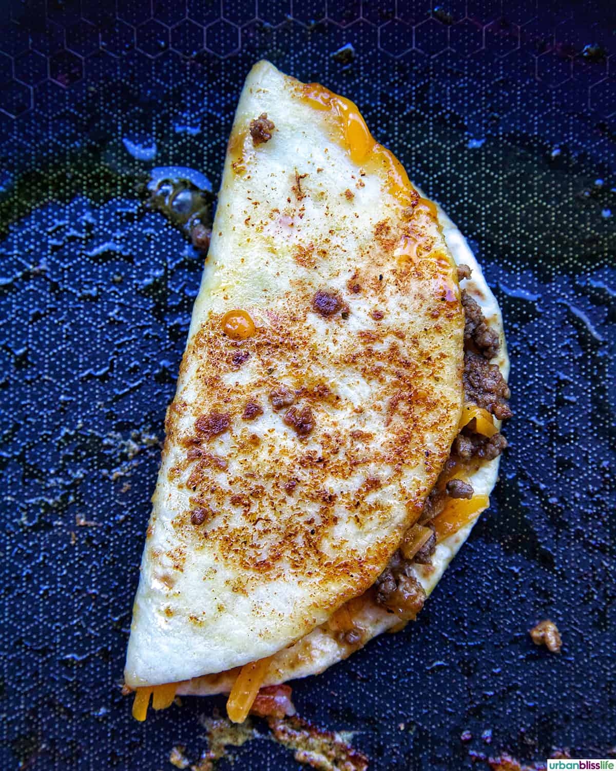 Crispy Beef Taco cooking in a skillet.