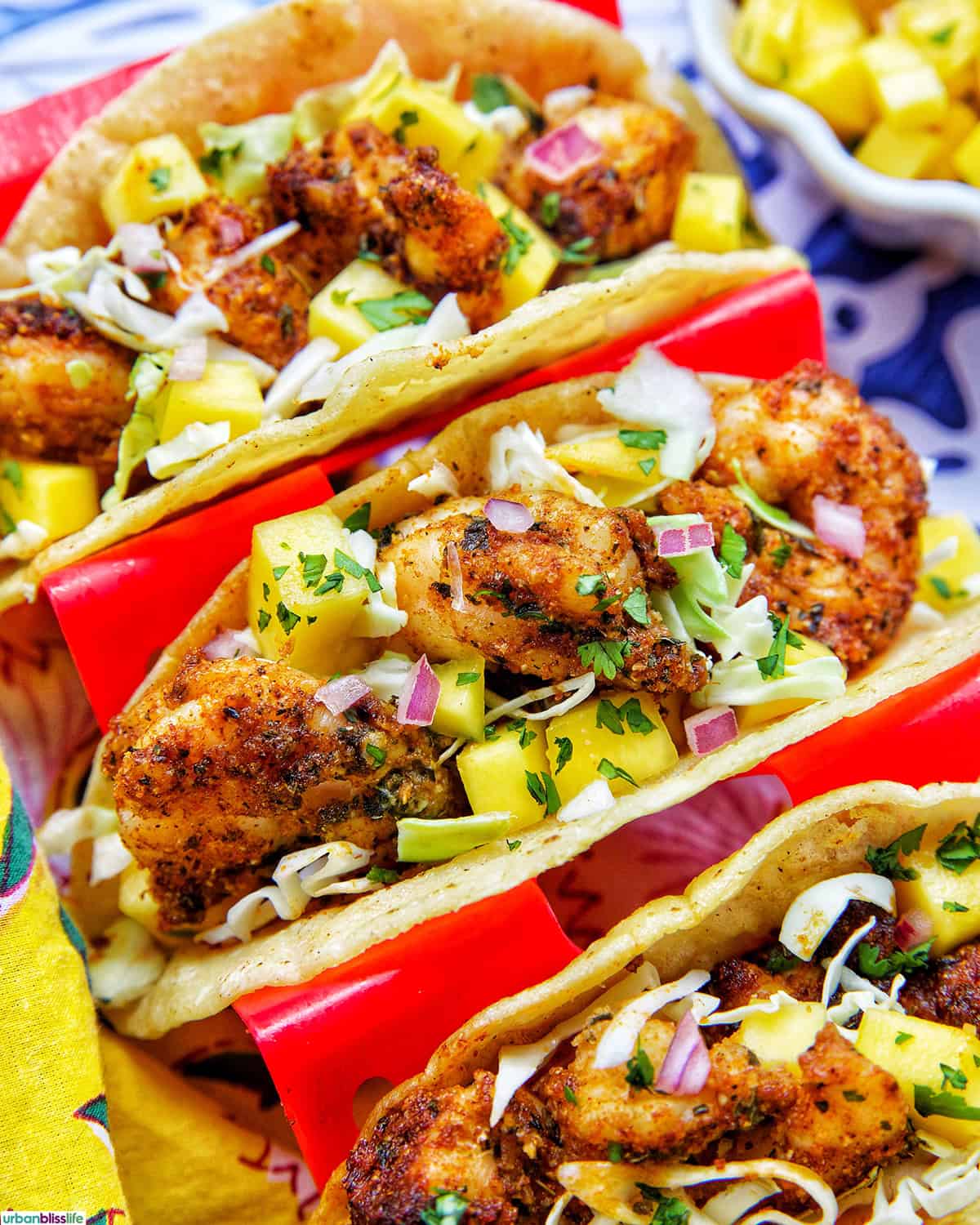 three air fryer shrimp tacos in a red taco stand.