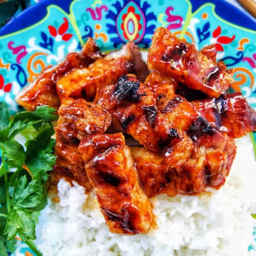colorful plate of Filipino grilled pork belly and rice.