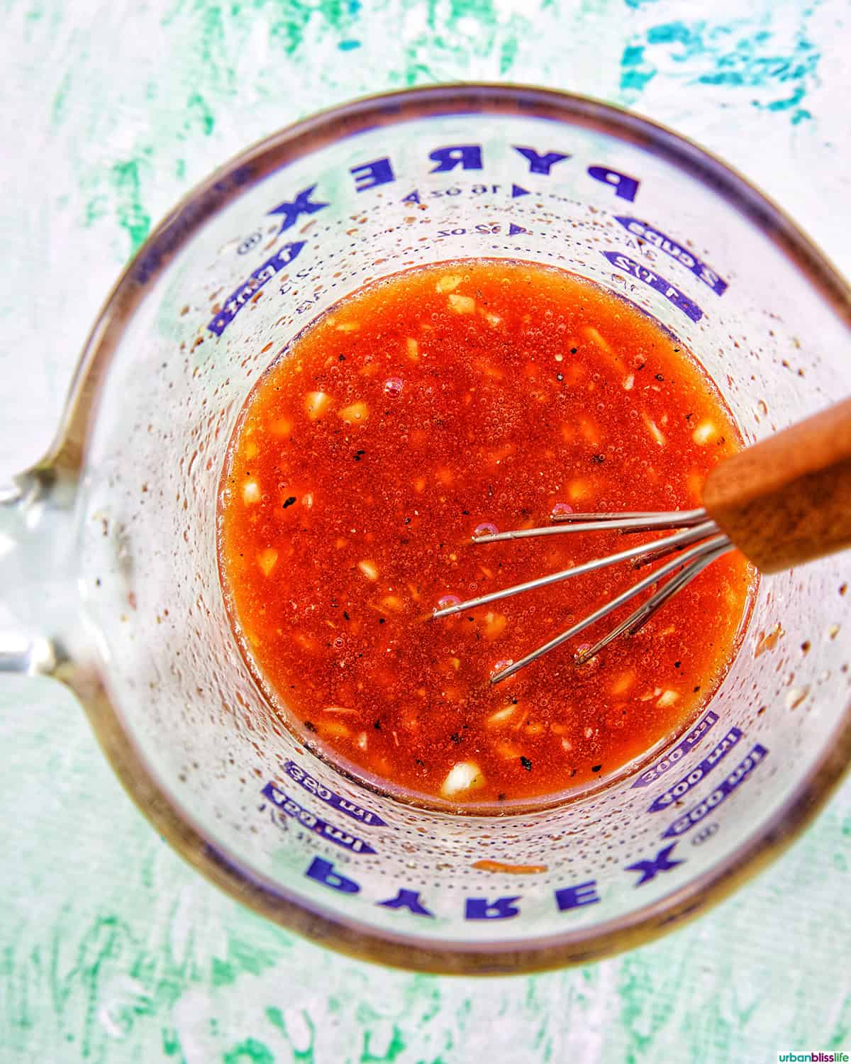 marinade for Filipino grilled pork belly in a bowl with whisk.
