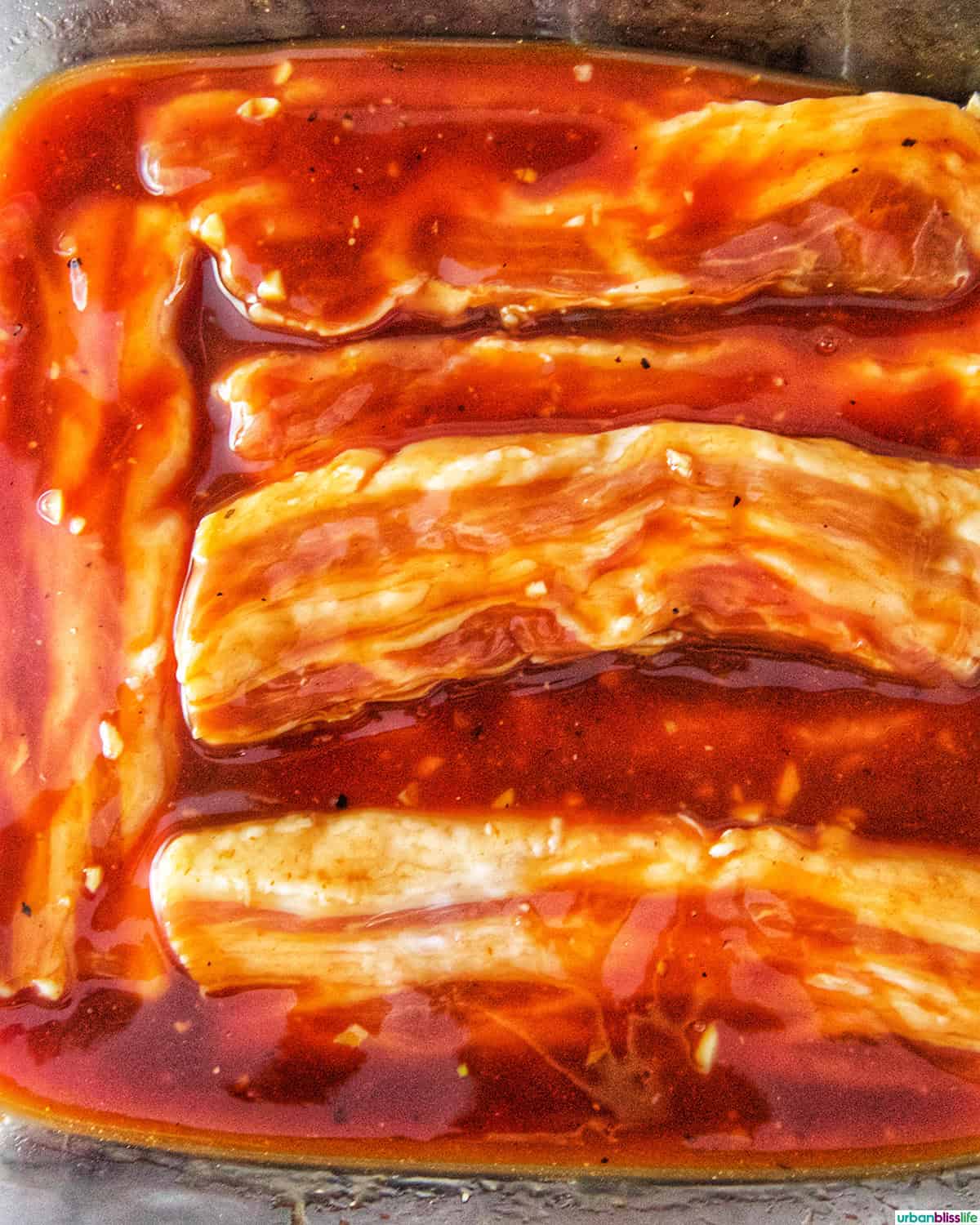 Filipino grilled pork belly marinating in sauce.