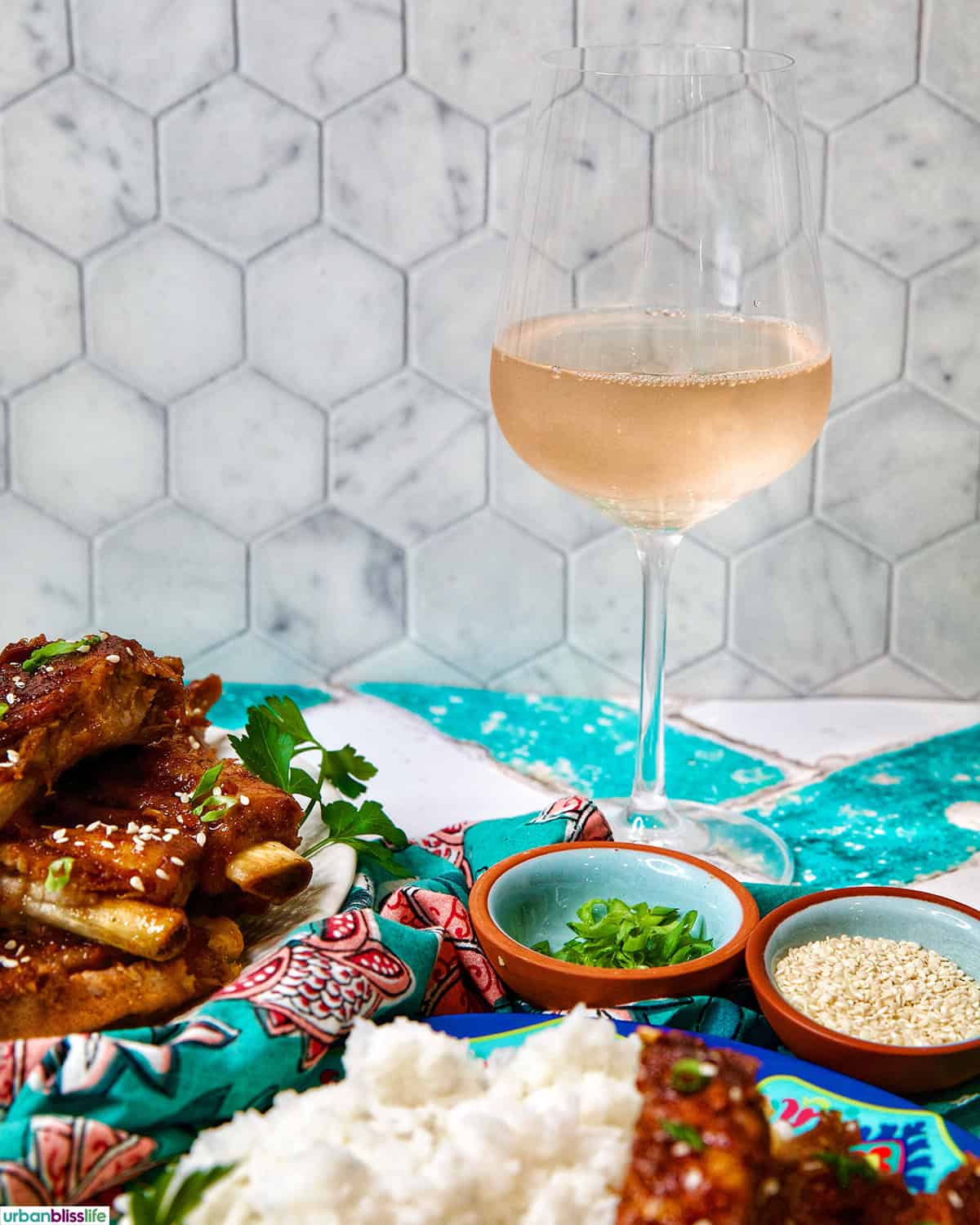 Instant Pot Asian Sticky Pork Ribs on two plates with a glass of rosé wine.