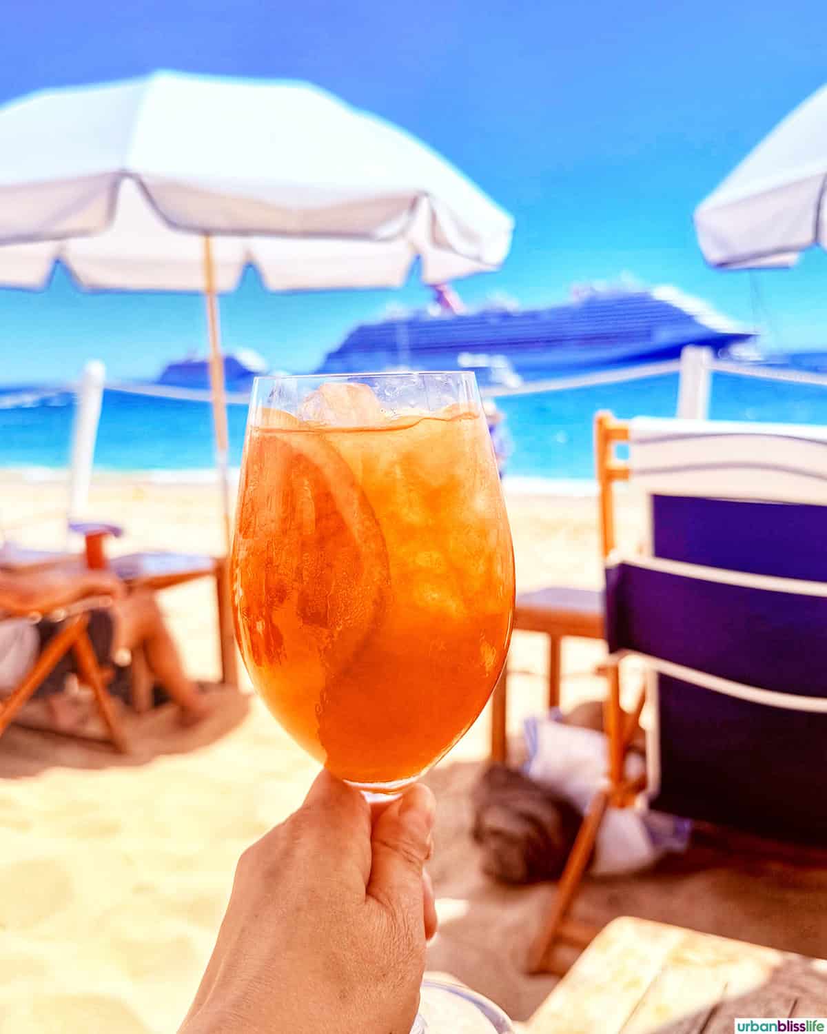 hand holding an aperol spritz at SUR Beach House in Cabo San Lucas, Mexico.
