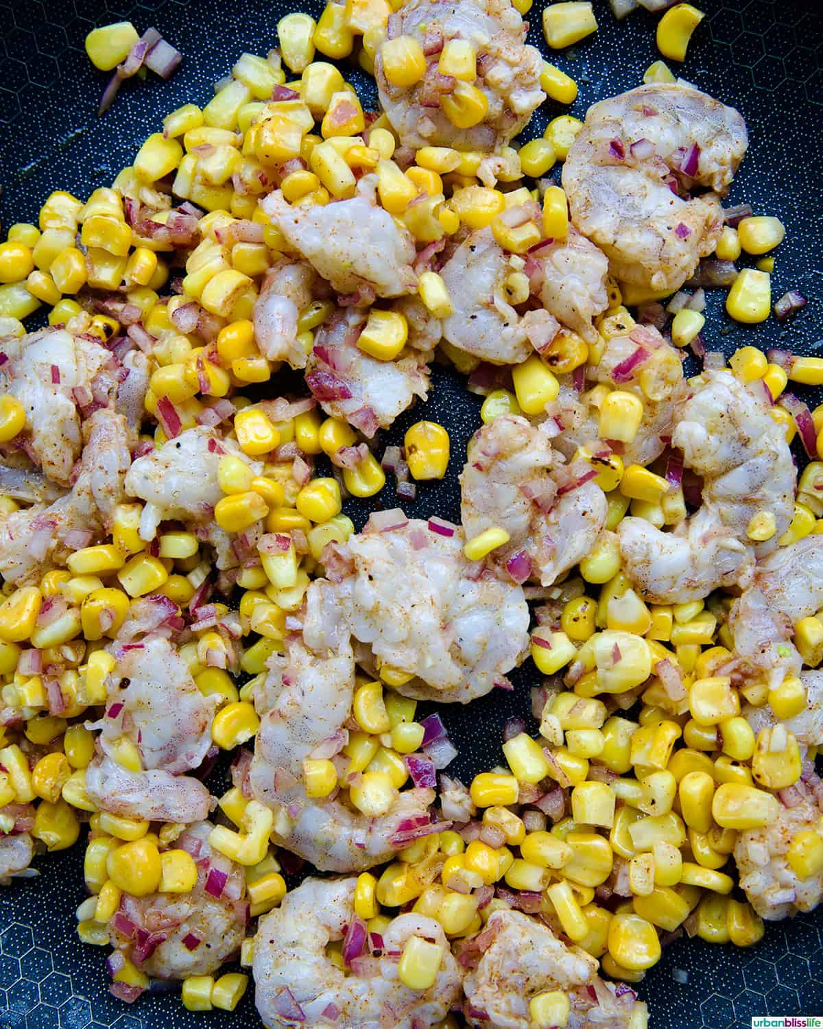 shrimp and corn cooking in a pan.