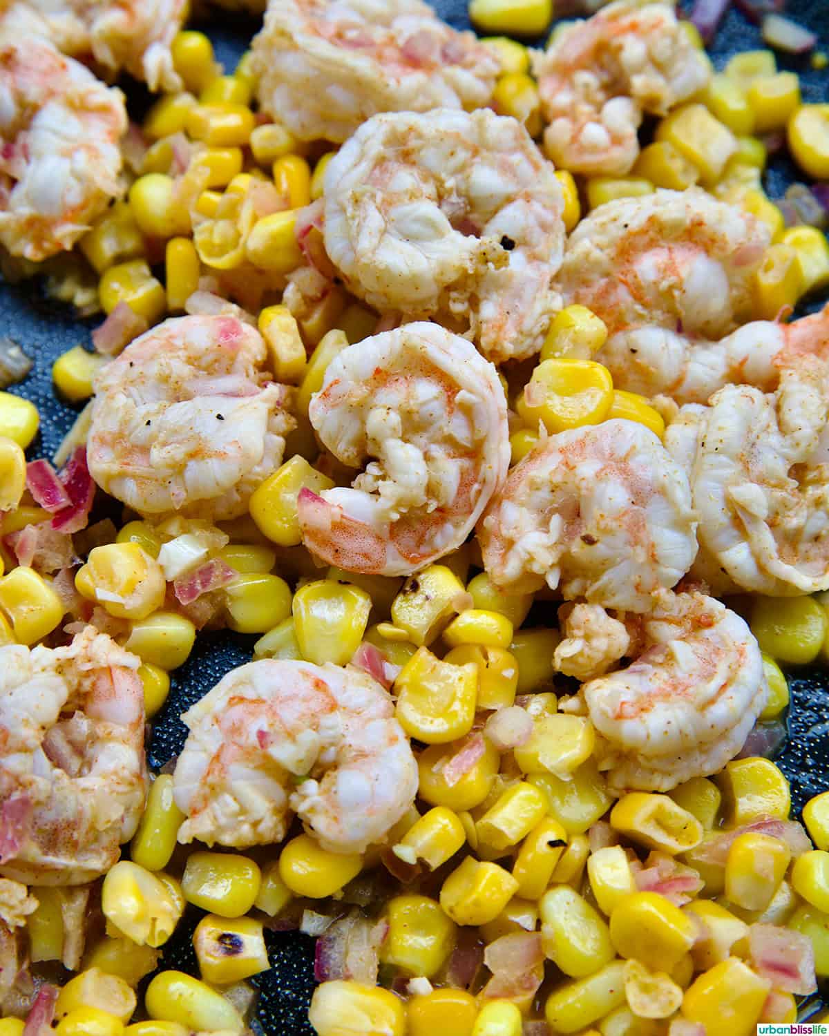shrimp and corn cooking in a pan.