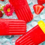 three strawberry fruit popsicles on ice