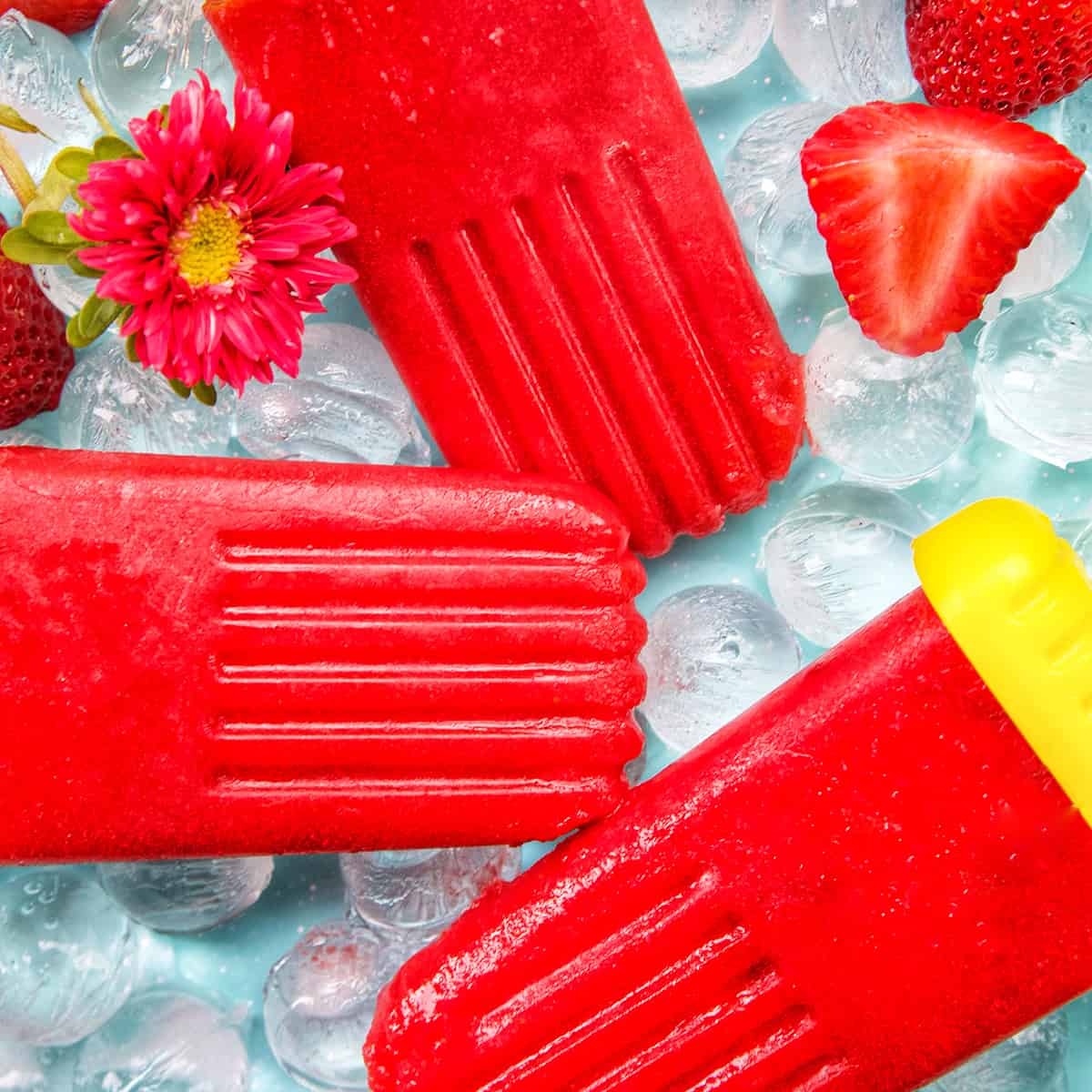 three strawberry fruit popsicles on ice