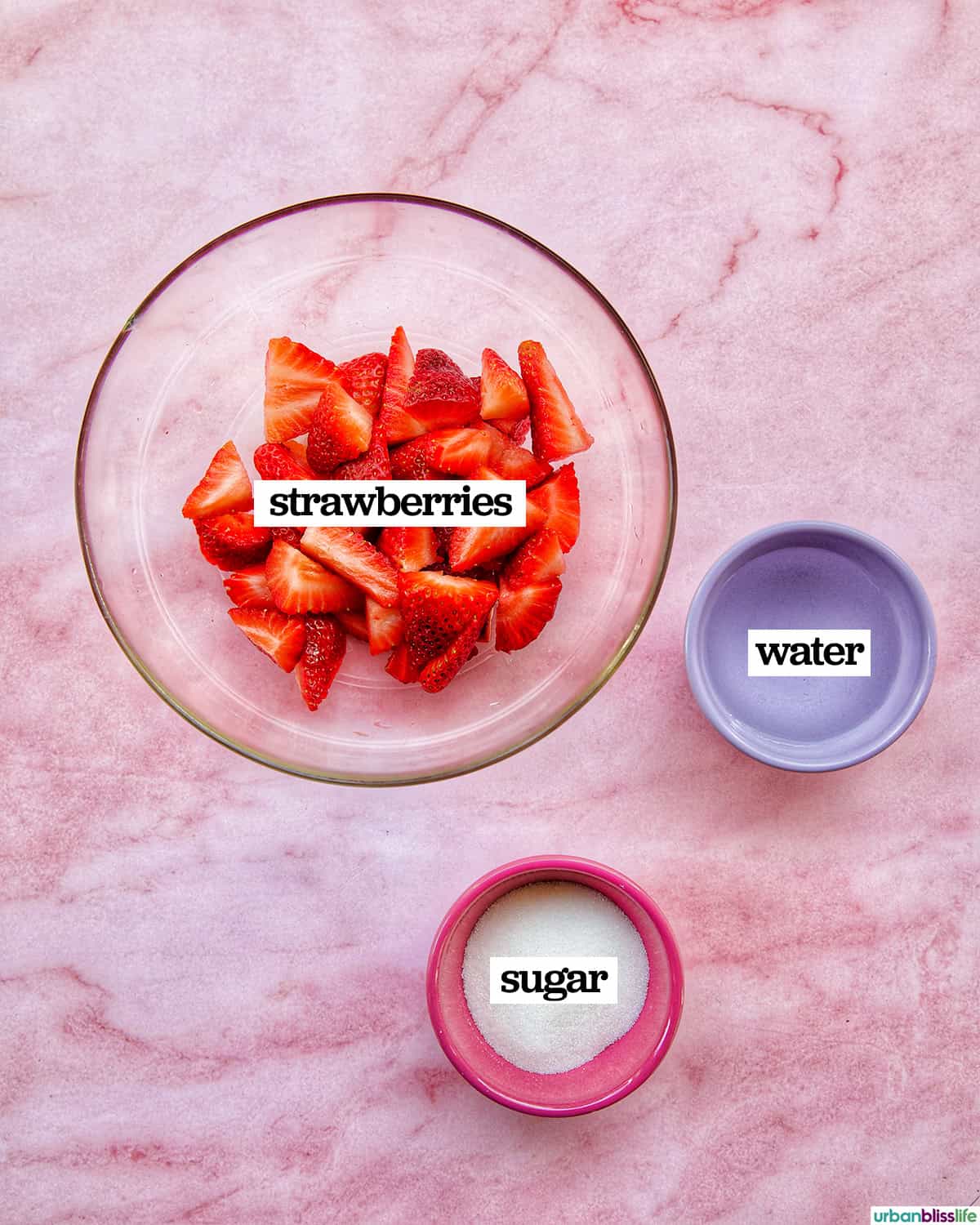bowls of ingredients to make strawberry fruit popsicles on ice.