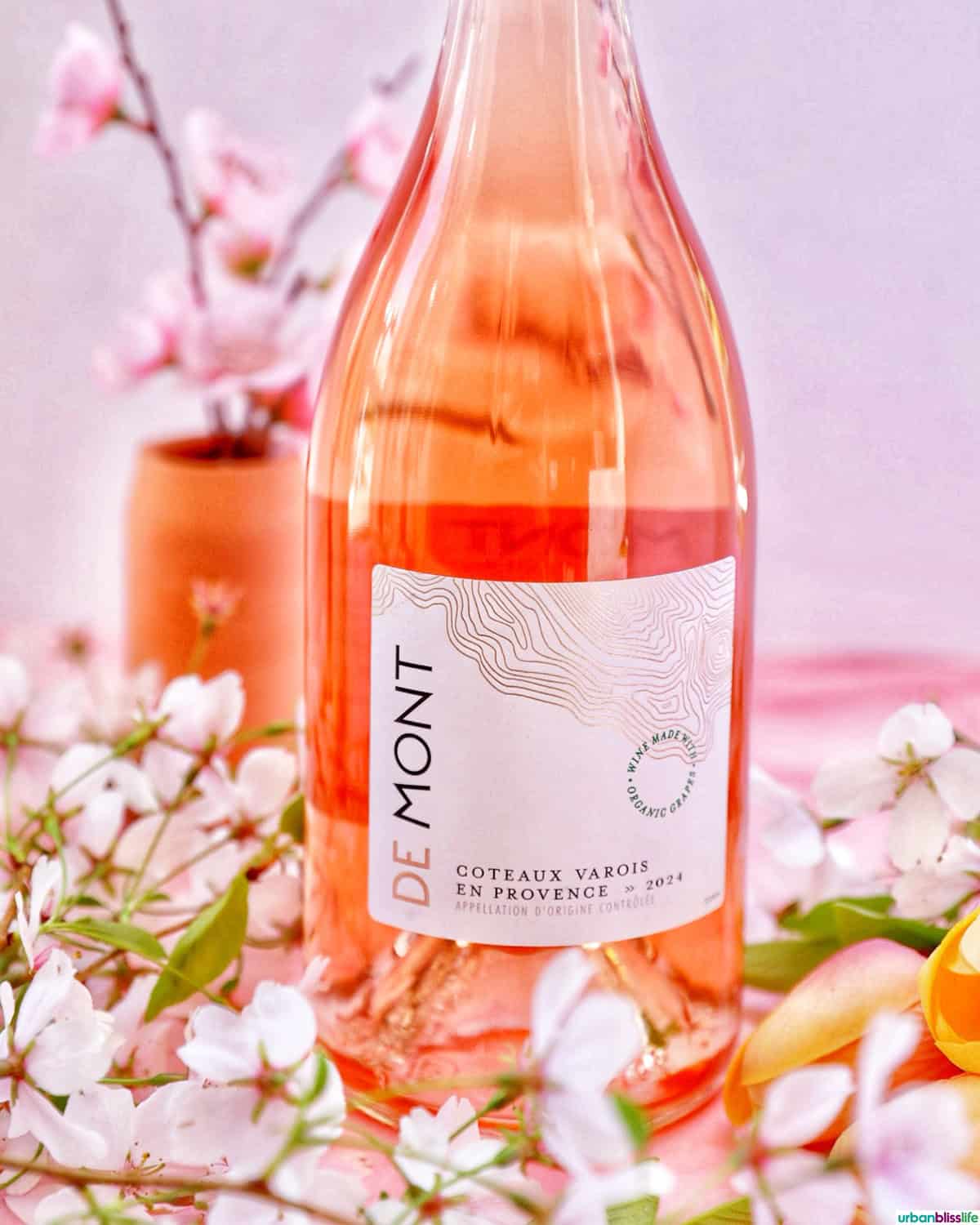 Bottle of DeMont Rose wine with cherry blossoms.