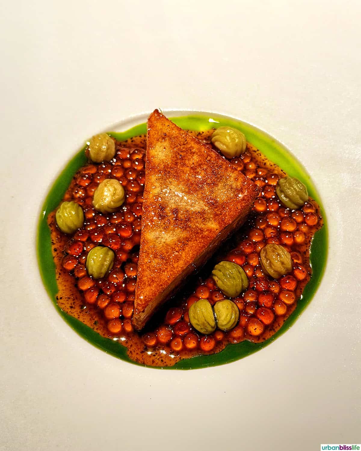 colorful slice of pork terrine with casabe, tapioca, mashed potato, nettle, and capersat El Chato restaurant in Bogota, Colombia.