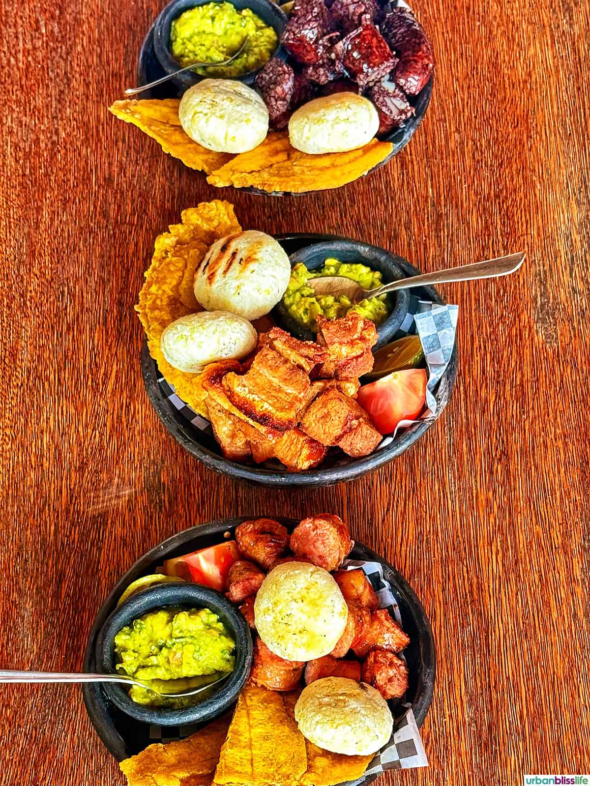 trio of meat dishes on a wood table in Manizales, Colombia.