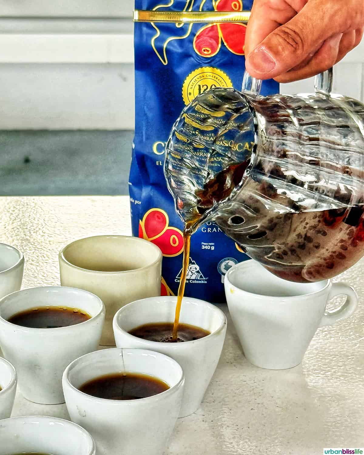 pouring fresh coffee into mugs at Hacienda Charrascal in Manizales, Colombia.