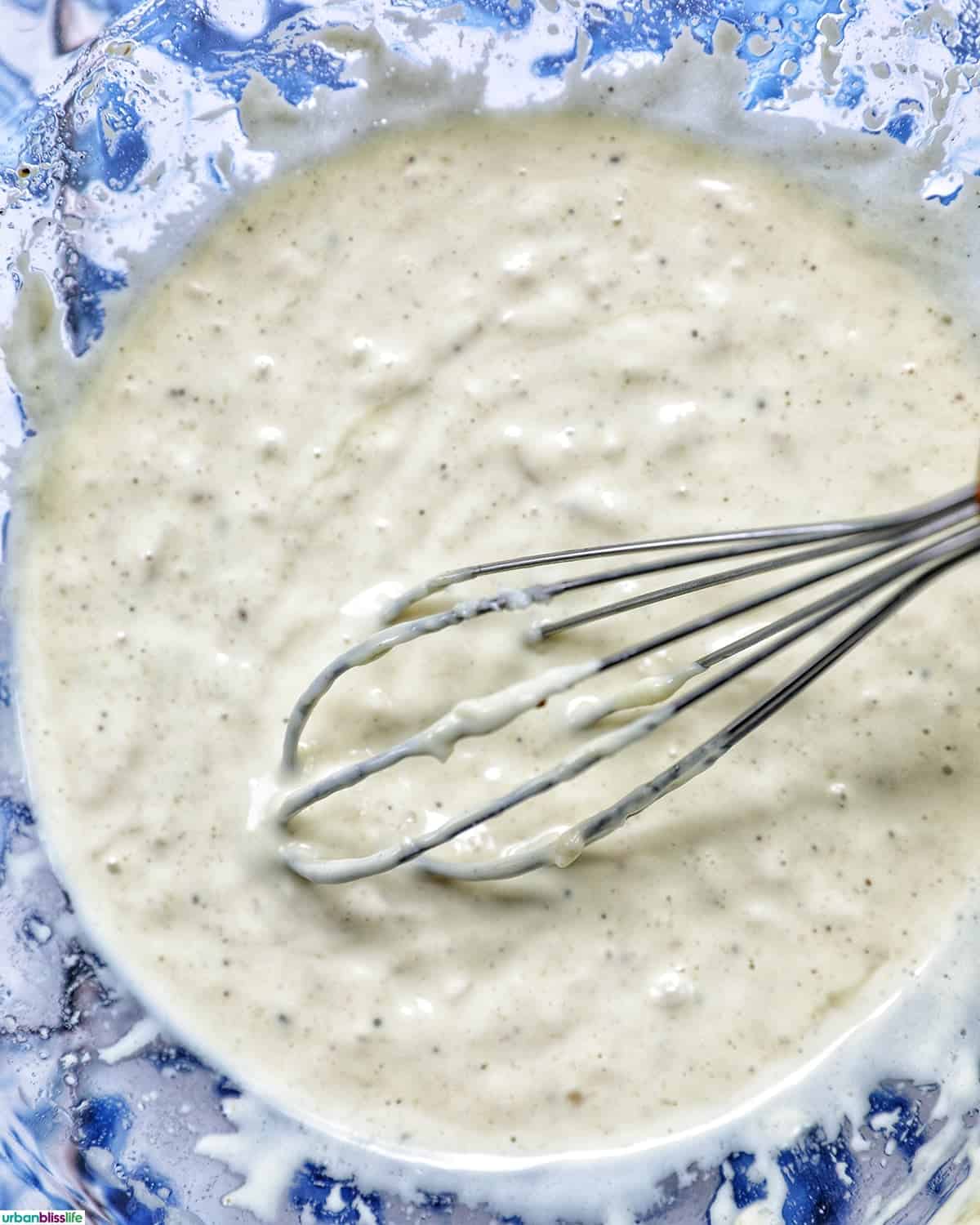 whisk in caesar dressing in a bowl.