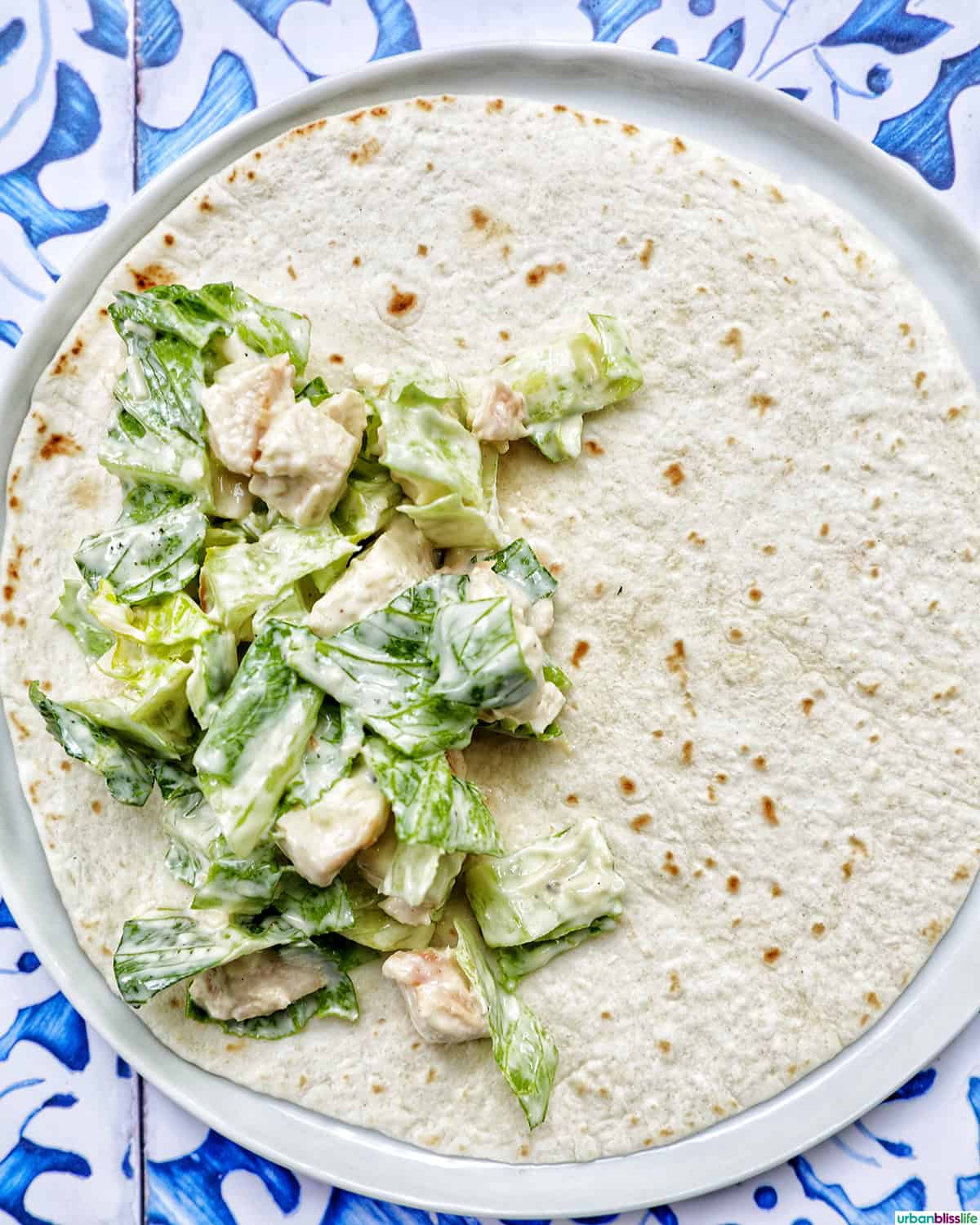 Chicken Caesar Salad on top of half of a tortilla wrap.