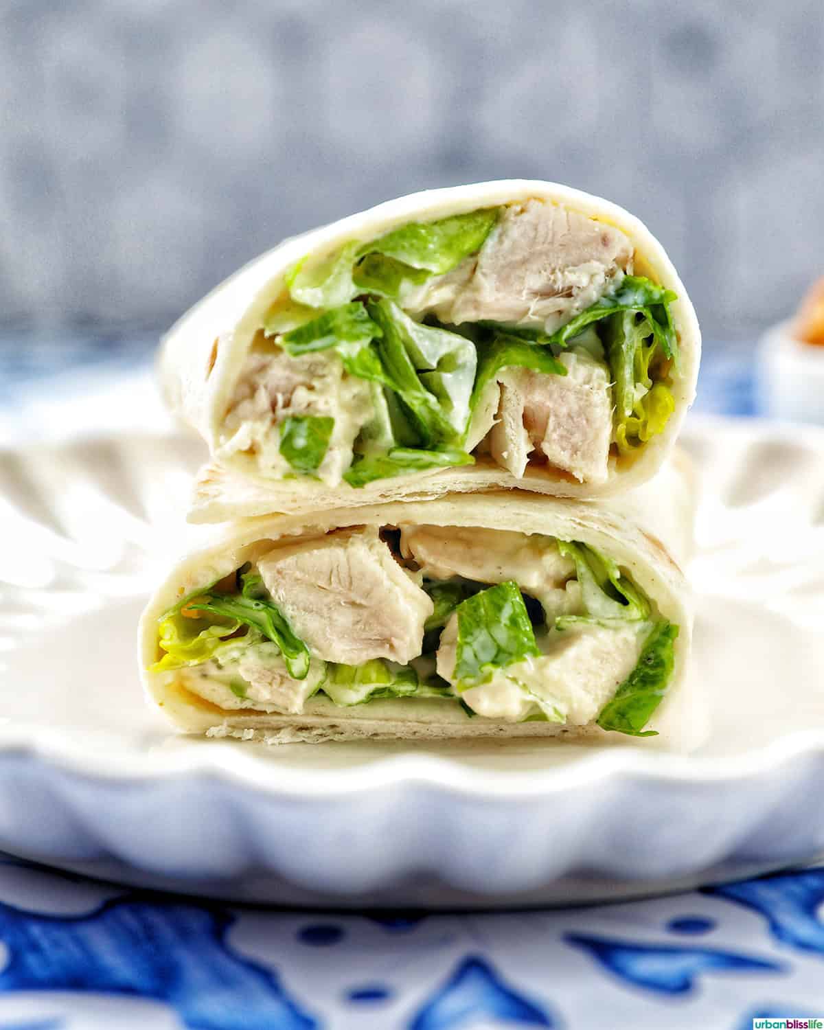 Chicken Caesar Salad Wrap sliced in half on a plate.
