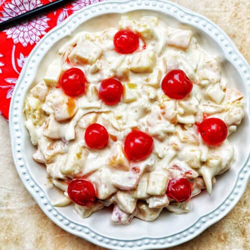 bowl of Filipino Fruit Salad topped with maraschino cherries.