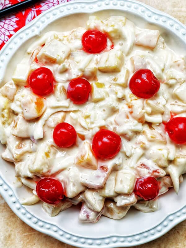 bowl of Filipino Fruit Salad topped with maraschino cherries.