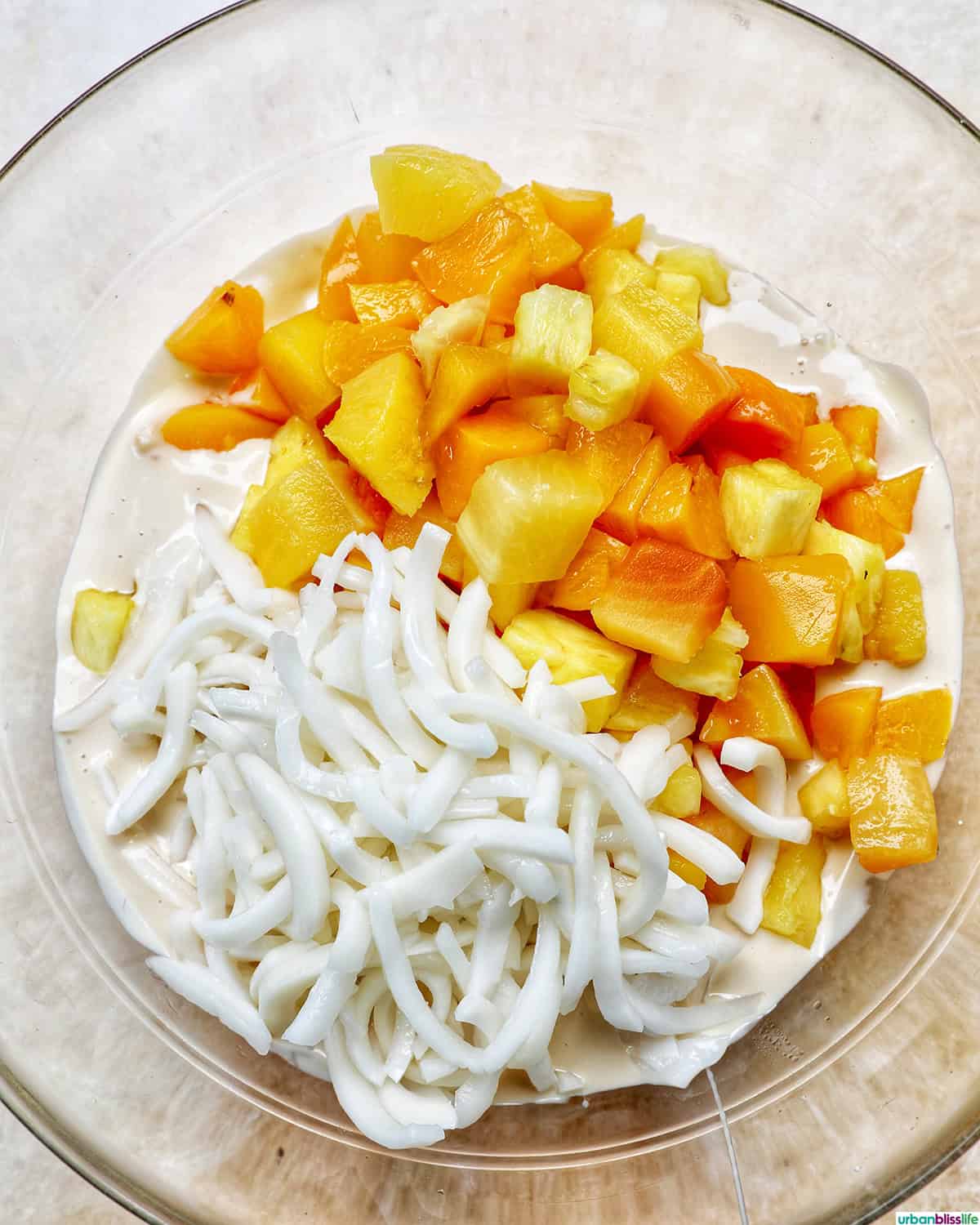 young coconut and tropical fruit salad in a bowl.