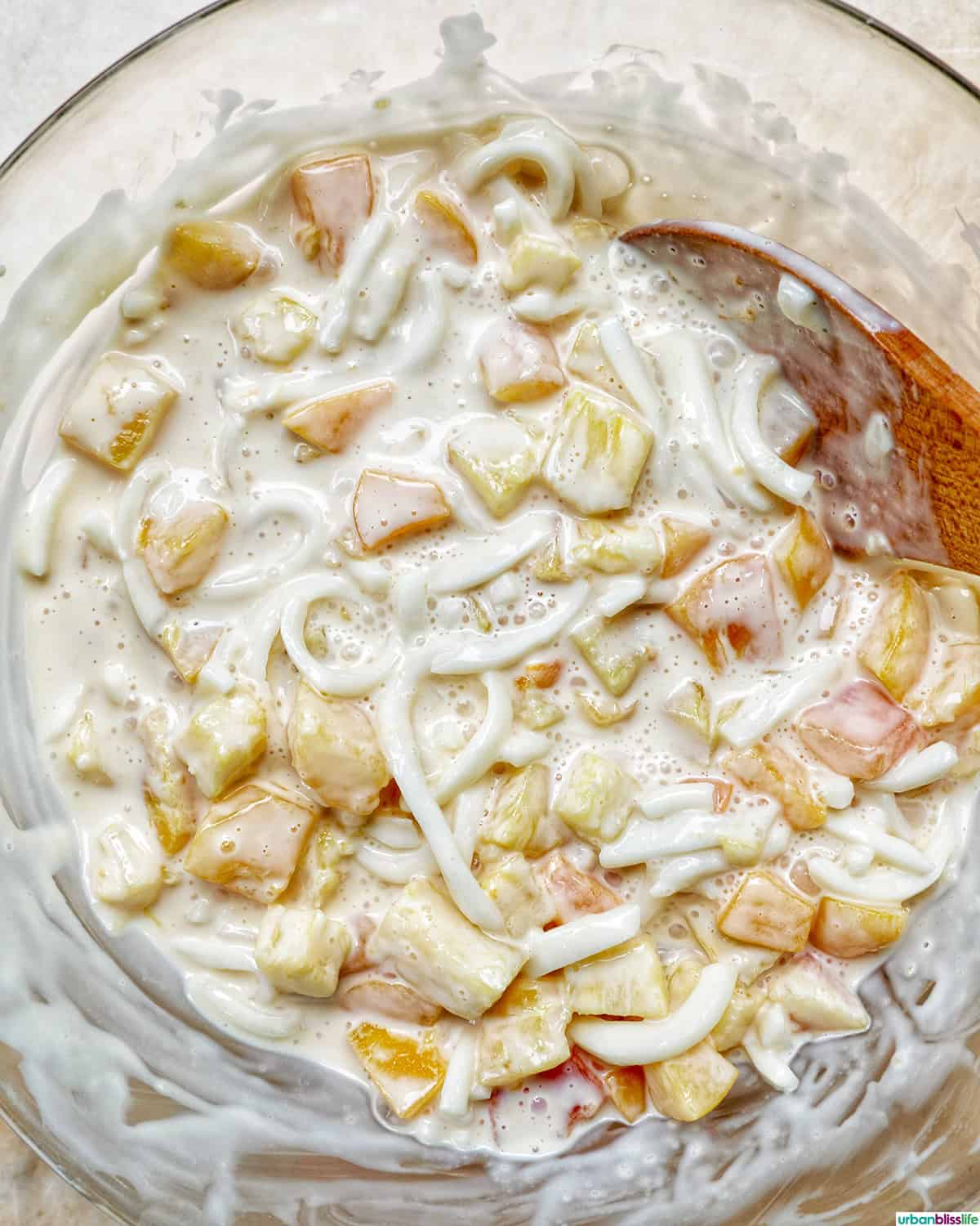 mixing together Filipino Fruit Salad.