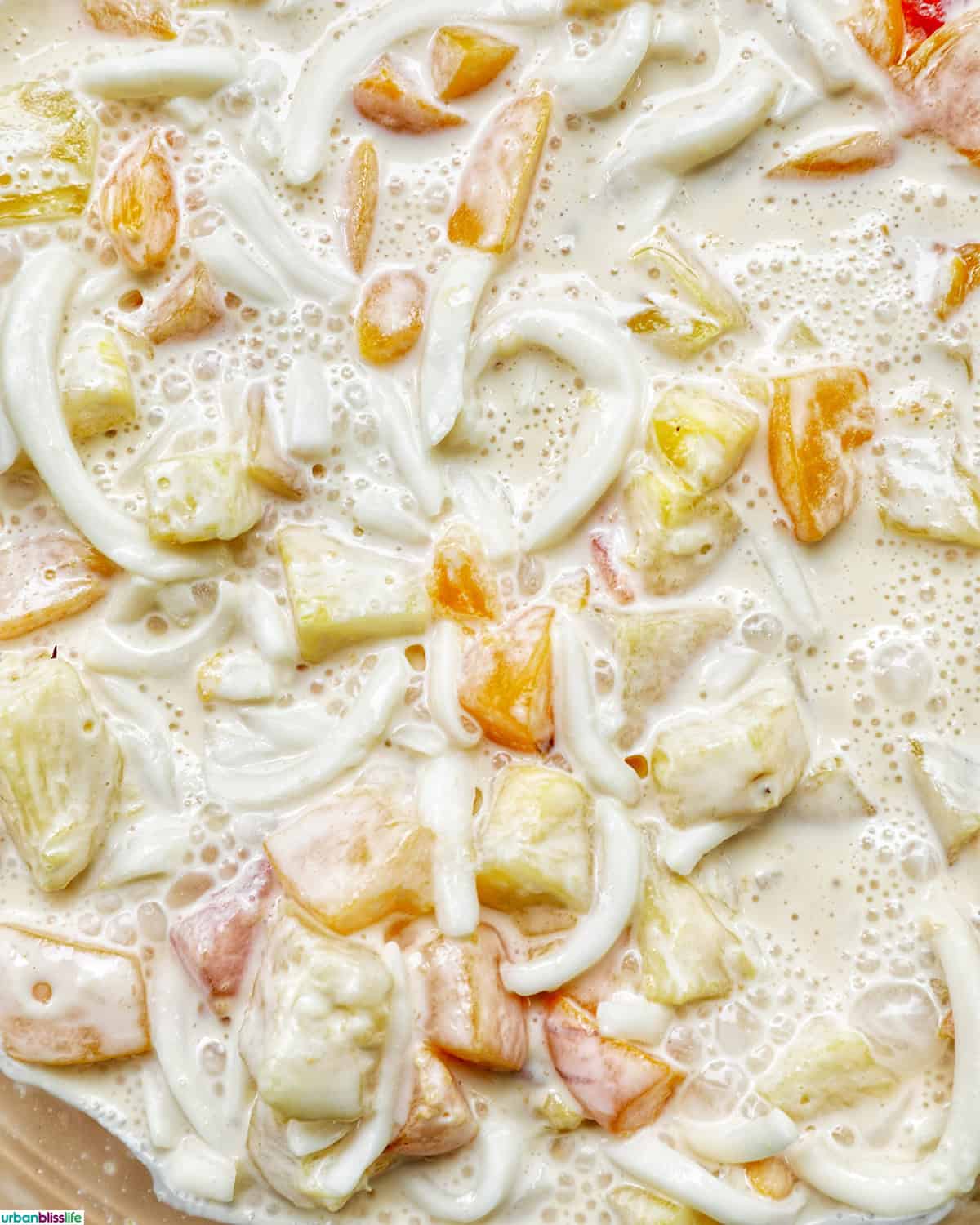 mixing together Filipino Fruit Salad.