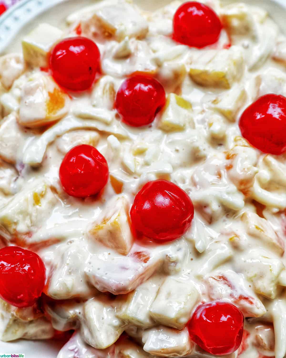 closeup bowl of Filipino Fruit Salad topped with maraschino cherries.