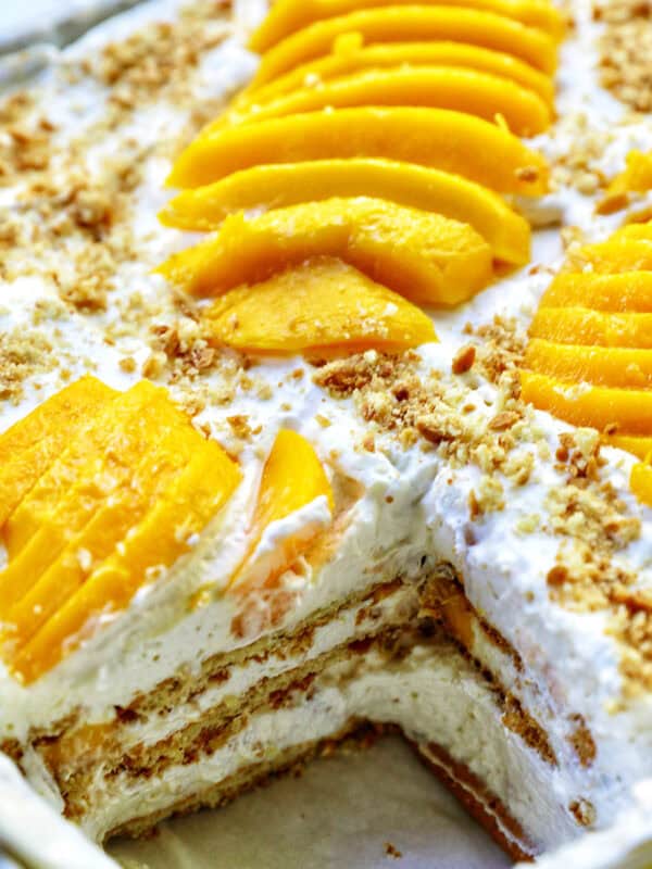 mango float dessert with a slice taken out so you can see the layers inside.