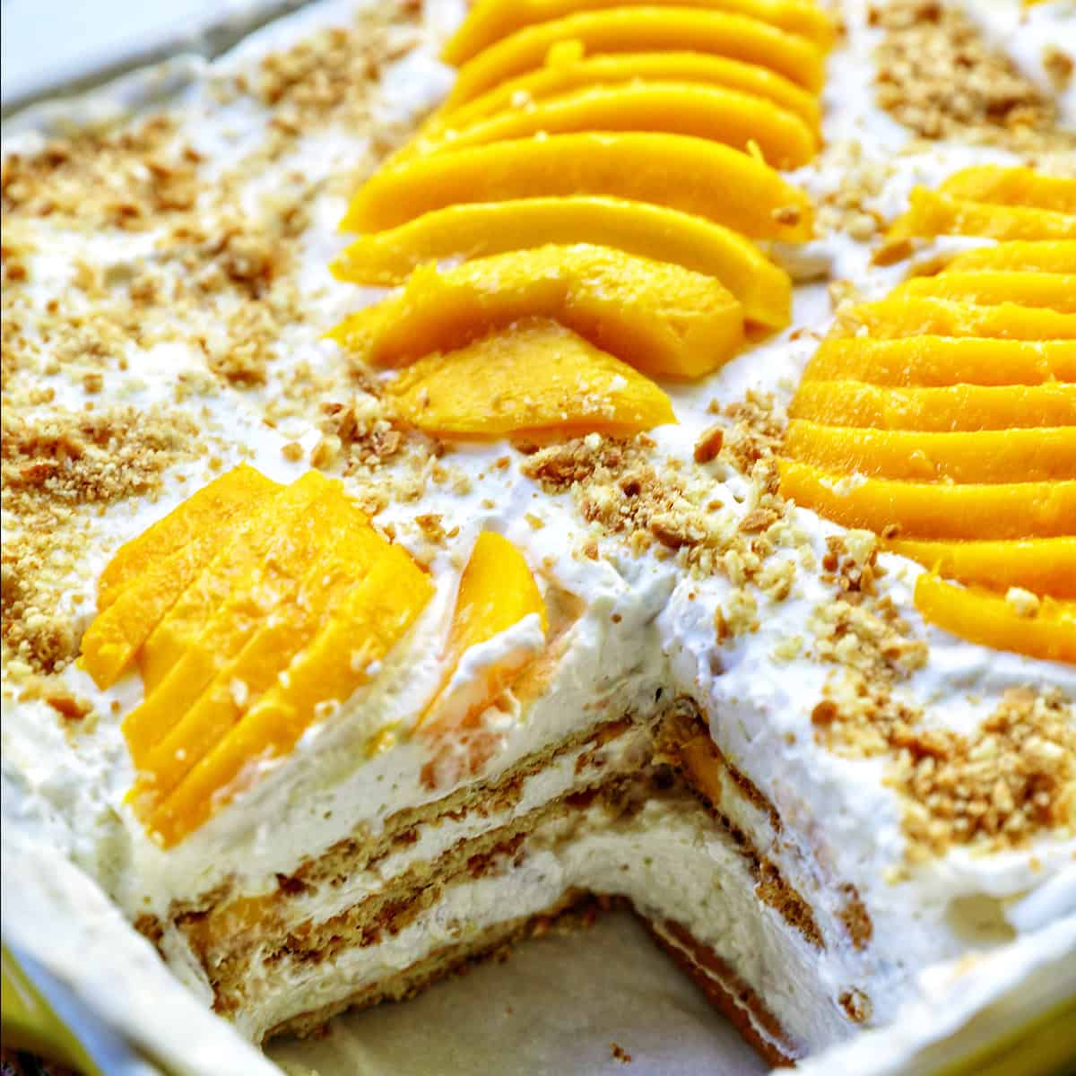 mango float dessert with a slice taken out so you can see the layers inside.