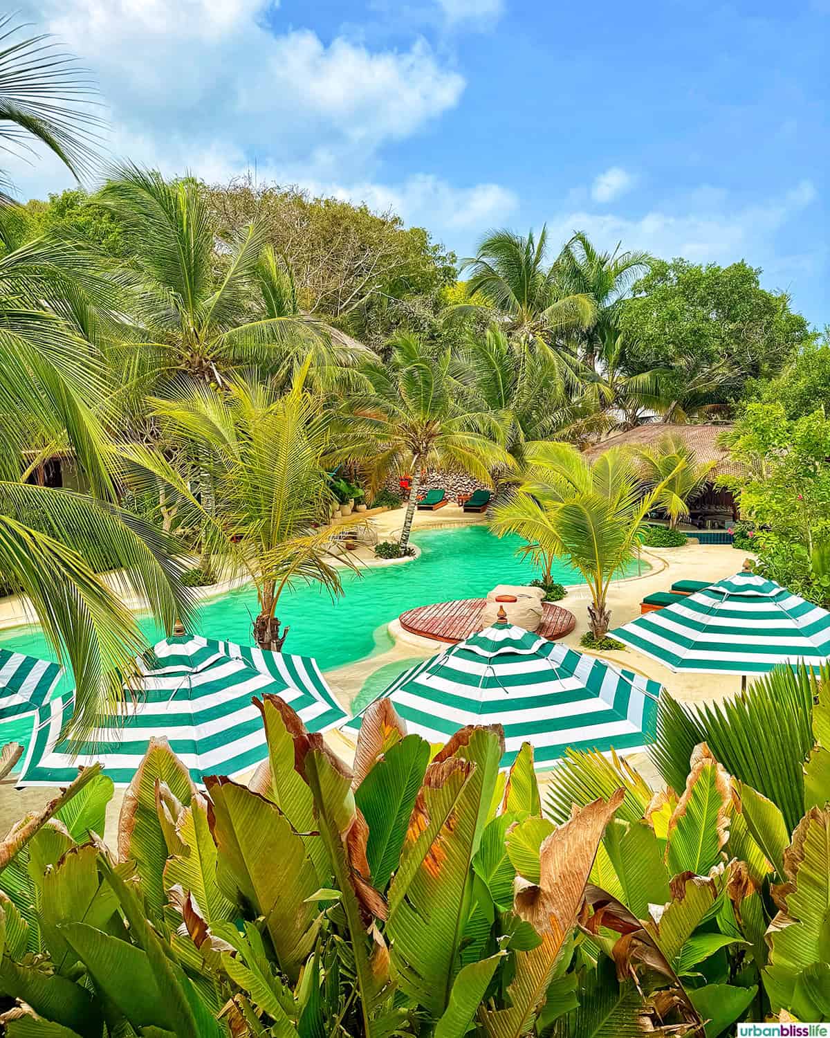 striped umbrellas, palm trees, and pools at Baru Island off the coast of Cartagena, Colombia.