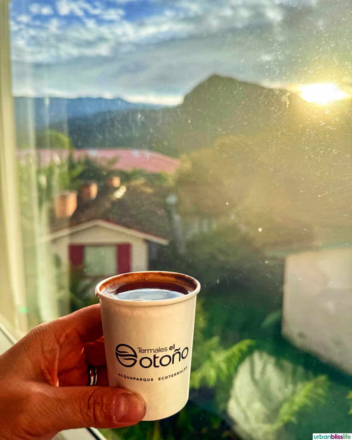cup of coffee against a window view of Manizales, Colombia at Hotel Termales del Otono.
