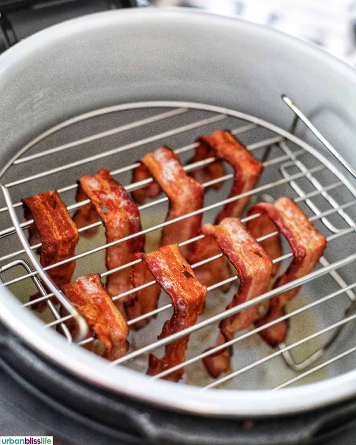 air fried bacon on racks in a Ninja Instant Pot air fryer.