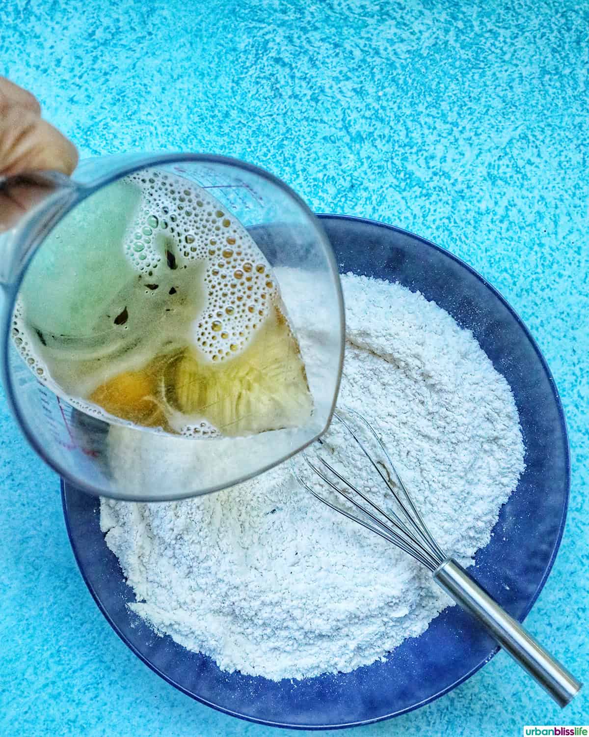 pouring beer into dry breading for beer battered fish.