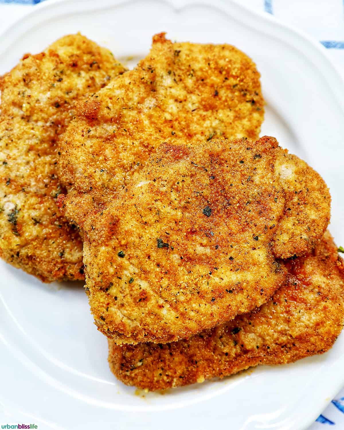 air fryer shake and bake pork chops on a white plate.