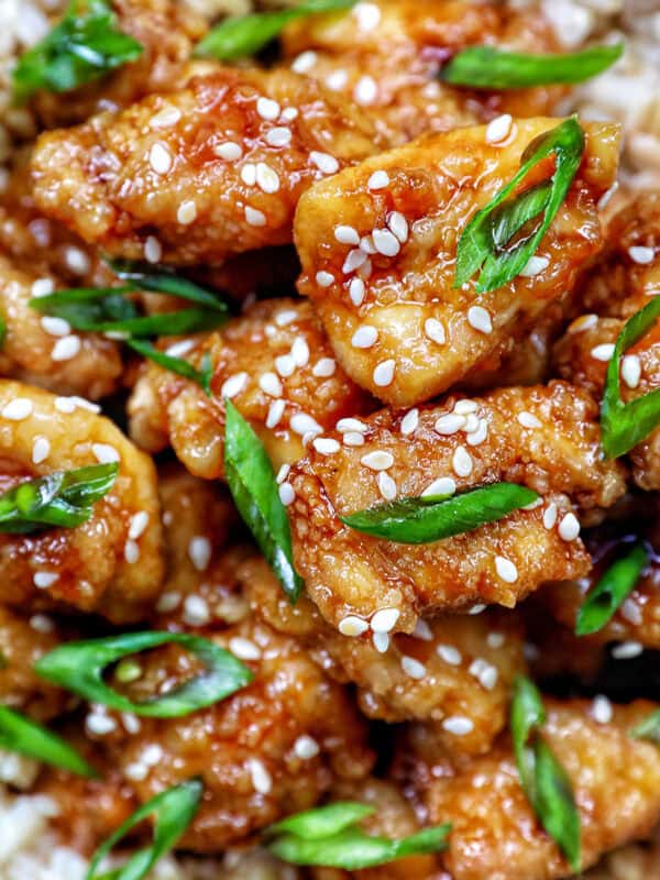 Air fryer teriyaki chicken over brown rice with herbs and chopsticks.