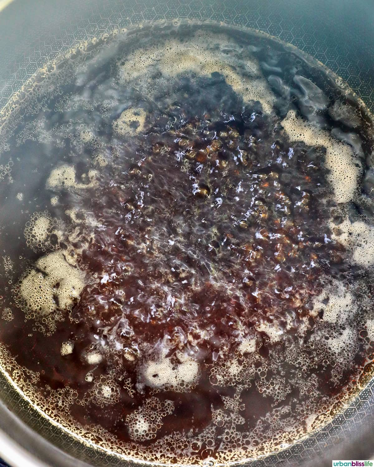 teriyaki sauce coming to a boil in a saucepan.
