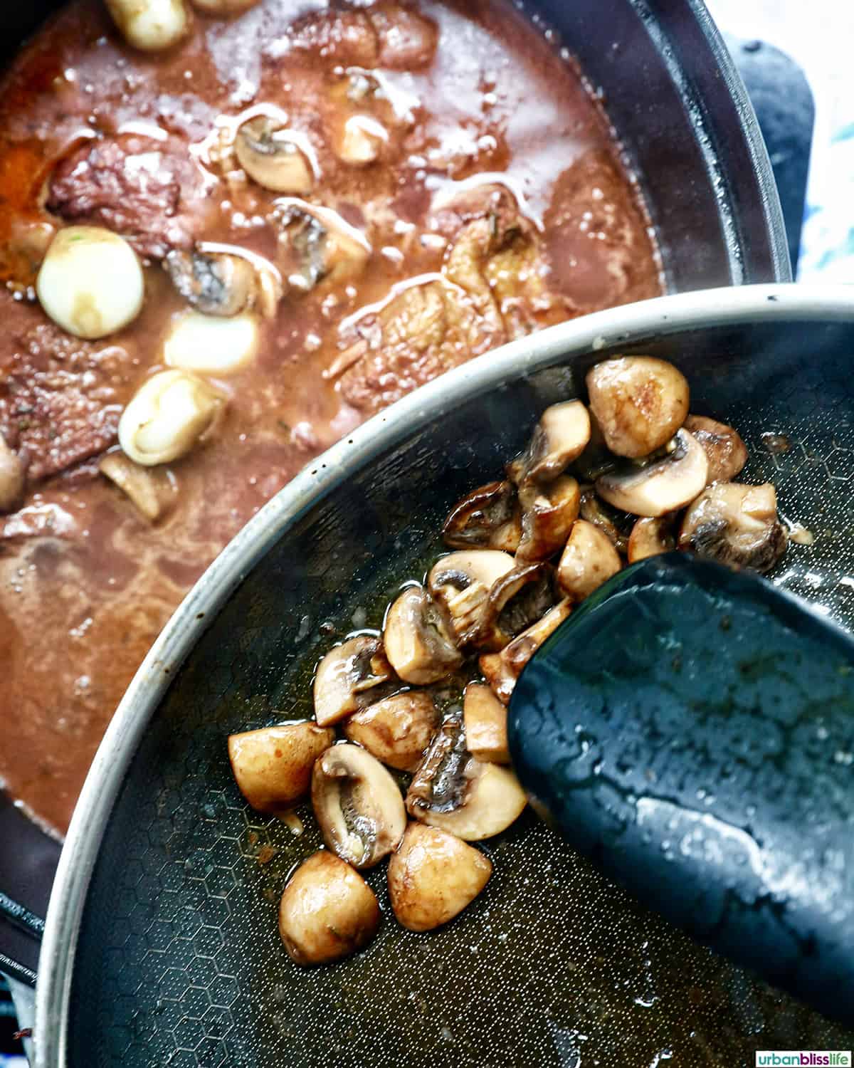 mushrooms being added to a pot of coq au vin.