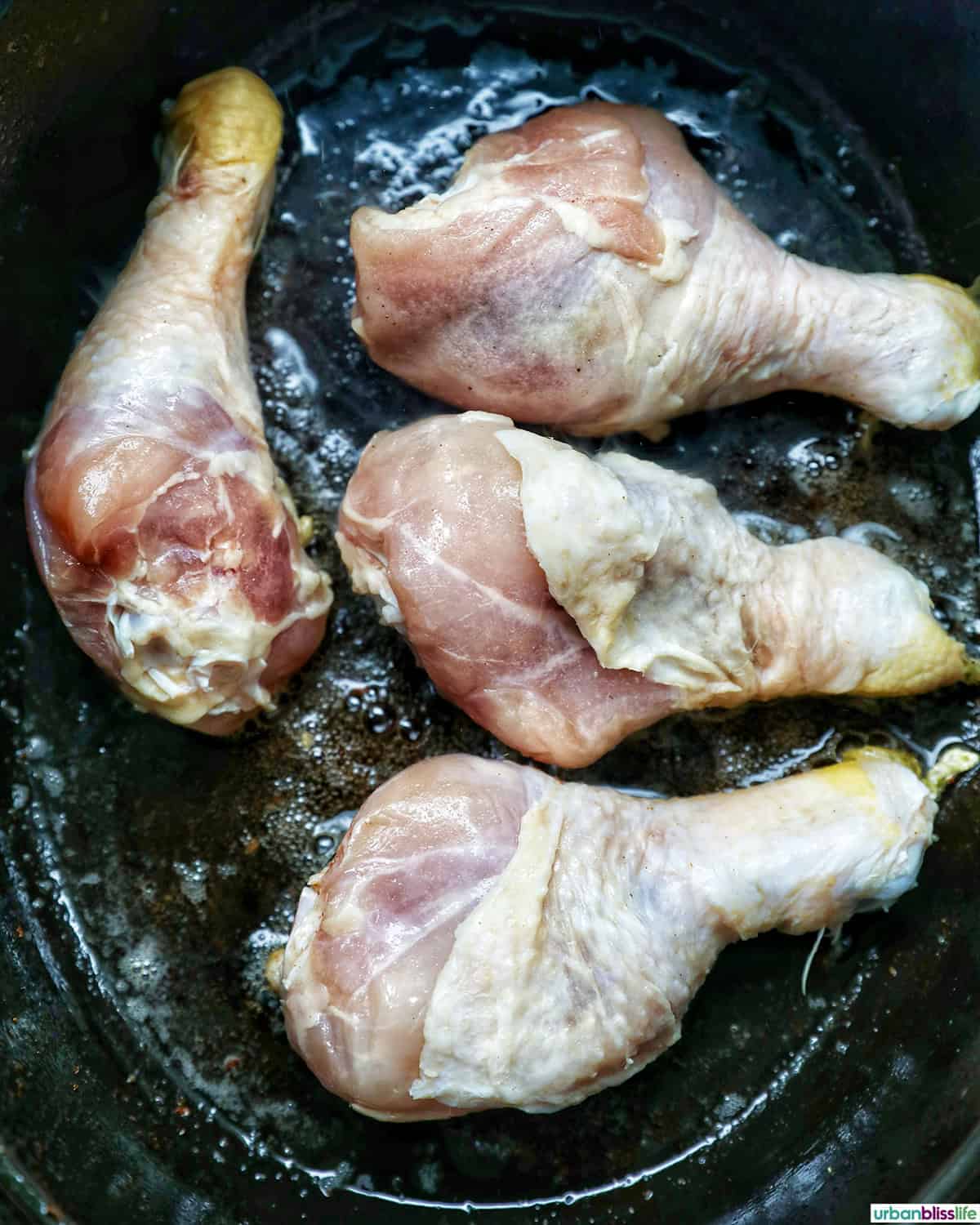 chicken pieces cooking in a dutch oven.