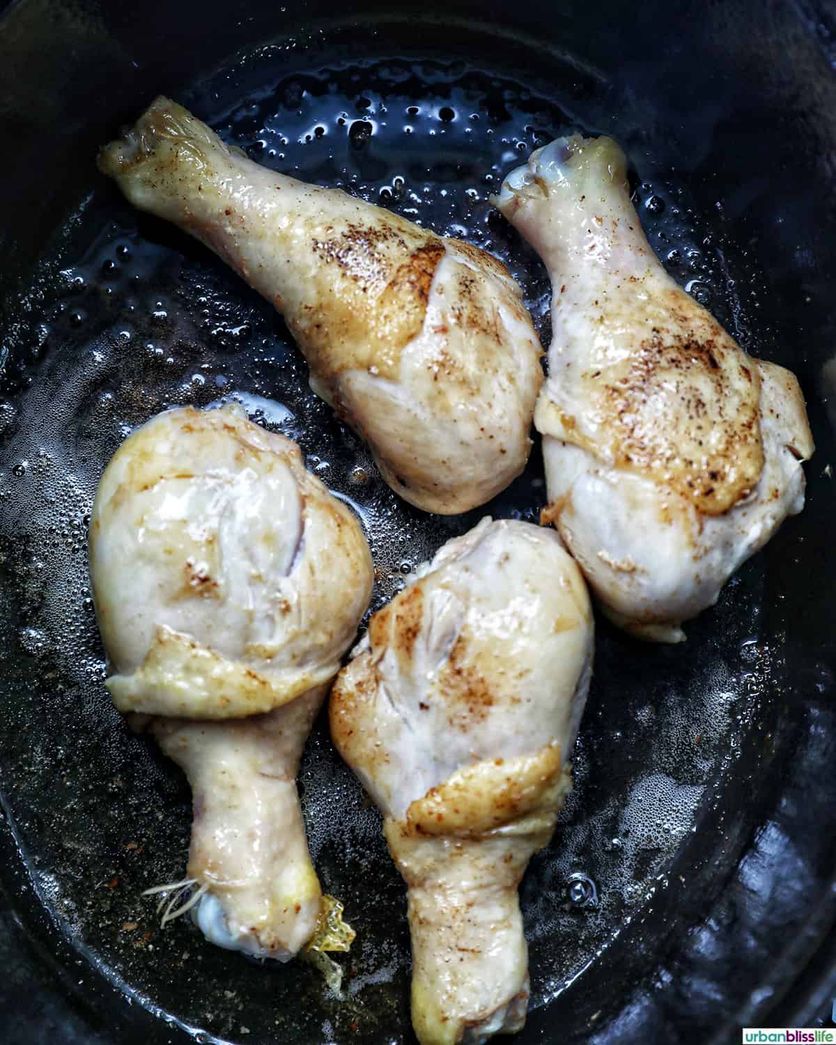chicken pieces cooking in a dutch oven.
